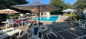 a pool with chairs and an umbrella next to a pool at Mondial Park Hotel in Fiuggi