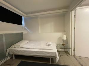 Dormitorio pequeño con cama y lámpara en The Old Factory, en Copenhague
