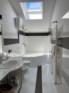 La salle de bains blanche est pourvue d'une baignoire et d'un lavabo. dans l'établissement Nonna Maria, à Airola