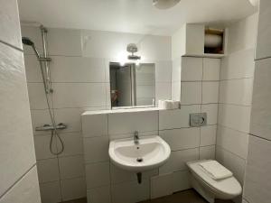 a white bathroom with a sink and a toilet at The Old Factory in Copenhagen