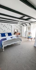 a bedroom with a bed with blue and white pillows at Britannia House Vintage B&B Cornwall in Helston