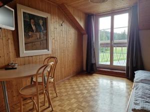 een kamer met een tafel en stoelen en een raam bij Auberge de la Couronne in Saignelégier