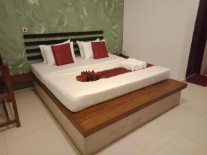 a bedroom with a large bed with red and white pillows at Monaara Leisure - Anuradhapura in Anuradhapura