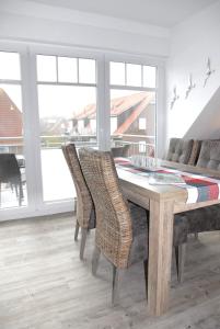 a dining room with a table and chairs and a couch at Mien Dröm in Norddeich
