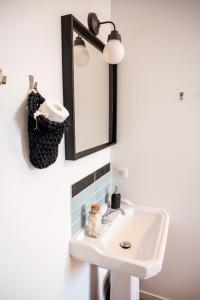 a bathroom with a sink and a mirror at AUBERGE KOSKENIA in Bidart