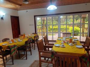 a dining room with tables and chairs with yellow tablecloths at Bethel's Villas in La Digue