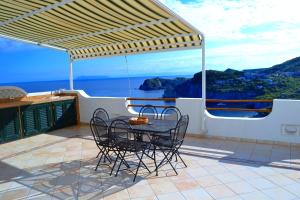 un tavolo e sedie su un balcone con vista sull'oceano di Maridea - La Terrazza a Ponza