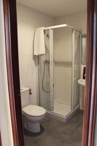 a bathroom with a toilet and a glass shower at Ikaztegietako Ostatua in Icazteguieta