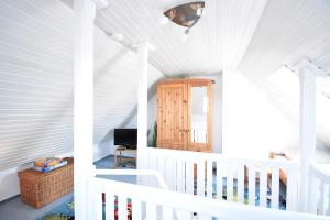 a white staircase in a home with a white ceiling at Morgenröte in Norddeich