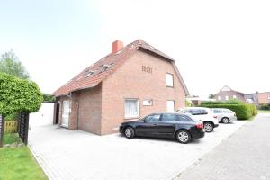 a black car parked in front of a brick house at Morgenröte in Norddeich