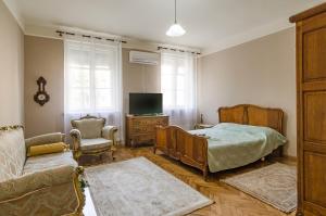 sypialnia z łóżkiem, telewizorem i kanapą w obiekcie Апартамент Гардения w Warnie