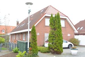 a red brick house with a car parked in front of it at Haus Krabbe in Norddeich