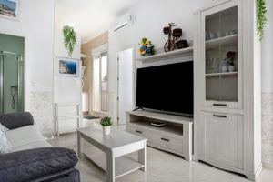 a living room with a flat screen tv in a white cabinet at Casa Centro Historico Barbate in Barbate