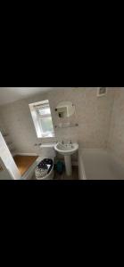 uma casa de banho com um lavatório, uma banheira e um WC. em Comfy, cozy house with disabled access em St Ives