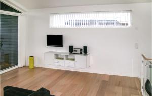 a living room with a flat screen tv on a white wall at Lovely Home In Frederikshavn With Kitchen in Frederikshavn
