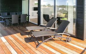 2 sillas sentadas en una terraza con una mesa en Nice Home In Frederikshavn With 3 Bedrooms And Wifi, en Frederikshavn