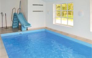 una piscina con un tobogán azul en una habitación en Amazing Home In Sby With Wifi, en Nordost