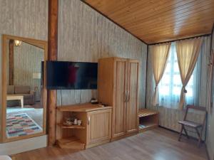 a living room with a television and a room with a couch at Complex Barite in Chernevo