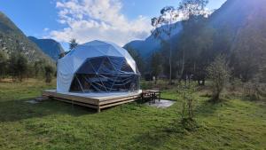 a tent in a field with mountains in the background at Olden Glamping - One with nature in Stryn