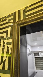 einen Spiegel mit einem goldenen Rahmen in einem Zimmer in der Unterkunft Luxurious 2 BHK Apartment Fully Furnished with All Major Electronics and Automation in Pune