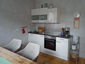 uma cozinha com electrodomésticos brancos e uma mesa e cadeiras em Ferienwohnung Haus Knäppen Size M em Oelde