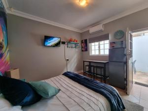 a bedroom with a bed and a table and a desk at 7 on Cecilia - Private Studio Apartment with Solar Power in Ballito