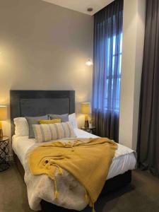 a bedroom with a bed with a yellow blanket on it at New York on Moorabool - Free Wi-Fi in Geelong