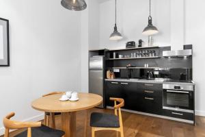 a kitchen with a table and a stove and refrigerator at New York on Moorabool - Free Wi-Fi in Geelong
