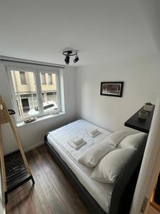 Habitación pequeña con cama y ventana en Dear apartments en Sarajevo
