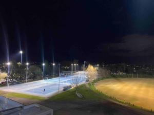 a tennis court at night with lights on at New York on Moorabool - Free Wi-Fi in Geelong