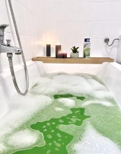 baño con bañera verde con nieve en SAPPHIRE APARTMENT: FREE PARKING + NETFLIX + BATHTUB, en Essen
