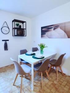mesa de comedor con sillas y mesa blanca en SAPPHIRE APARTMENT: FREE PARKING + NETFLIX + BATHTUB, en Essen