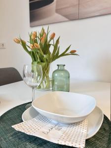 un tazón blanco en un plato sobre una mesa con un vaso en SAPPHIRE APARTMENT: FREE PARKING + NETFLIX + BATHTUB, en Essen
