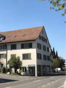 a white building on the side of a street at 2 Zimmer mit Seeblick Bad geteilt auf der Etage in Kilchberg