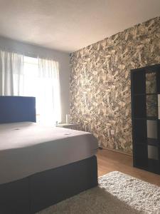 a bedroom with a bed and a wall covered in logs at 2 Zimmer mit Seeblick Bad geteilt auf der Etage in Kilchberg