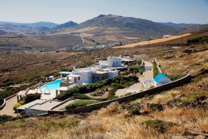 a group of white buildings on a hill at Lia beach Estate in Mikonos