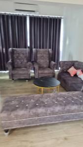 a living room with a couch and chairs and a table at Sitiawan Acacia Homestay in Sitiawan