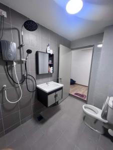 een badkamer met een douche, een wastafel en een toilet bij Sitiawan Acacia Homestay in Sitiawan