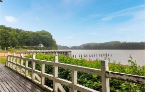 una valla de madera junto a un lago con muelle en Nice Home In Bytw With Wifi, en Bytów