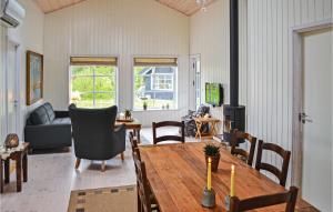 フレデリクスハウンにあるAmazing Home In Frederikshavn With 3 Bedrooms And Wifiのリビングルーム(テーブル、ソファ付)