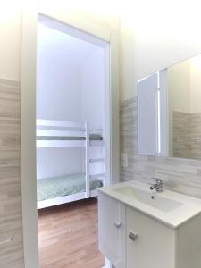 a white bathroom with a sink and a mirror at [RHO FIERA] Apartment near the Metro in Pero