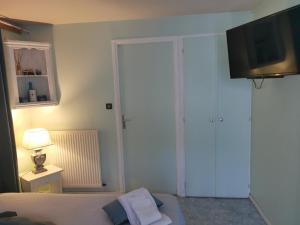 een slaapkamer met een bed en een tv aan de muur bij Les Tamaris in Campsegret