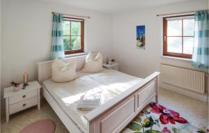 a white bed in a room with two windows at Amazing Home In Prerow With Wifi in Prerow