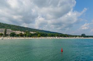 a red buoy in the water in front of a beach at Апартамент Жасмин in Varna City