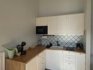 a kitchen with white cabinets and a counter top at APARTAMENT W TRZĘSACZU in Trzęsacz
