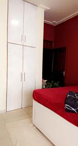 a bedroom with white cabinets and a red wall at Lajungle Muyenga in Kampala
