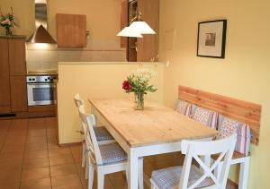 una cocina con una mesa con un jarrón de flores. en Ferienhof Landlord, en Fehmarn