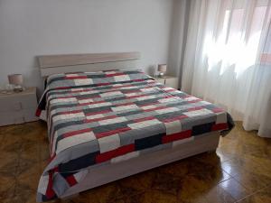 ein Bett mit einer Decke in einem Schlafzimmer in der Unterkunft Casa di Nzino in Guglionesi
