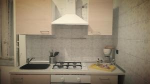 una piccola cucina con fornelli e lavello di Napulè a Napoli Altre 3 foto