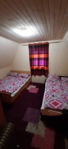 twee bedden in een kleine kamer met een gordijn bij AWilaBorova# in Zlatibor